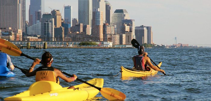 People riding kayaks on the Hudson River along Manhattan.