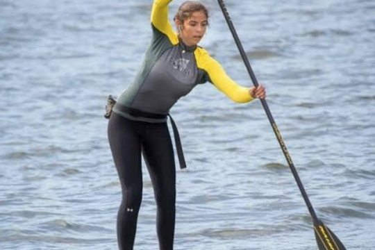 a woman standing next to a body of water