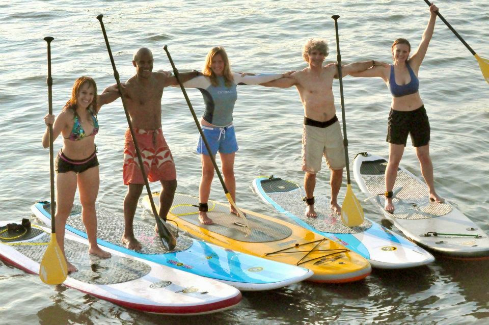 a group of people standing next to a body of water