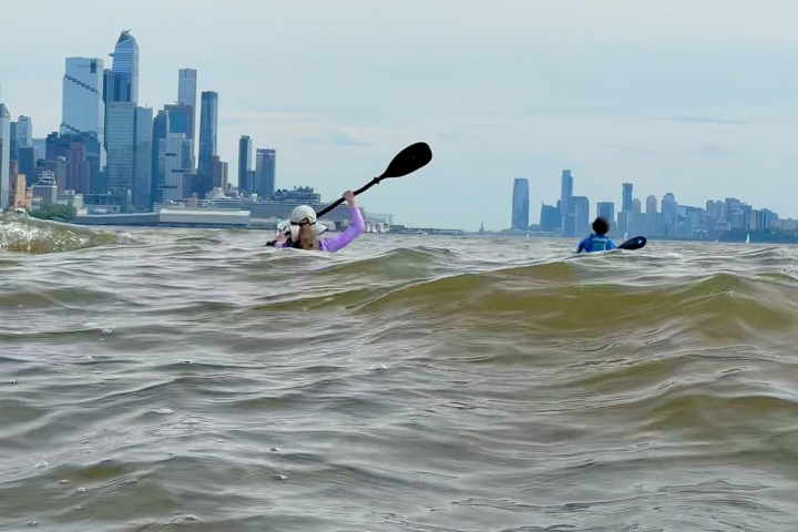 a group of people standing next to a body of water