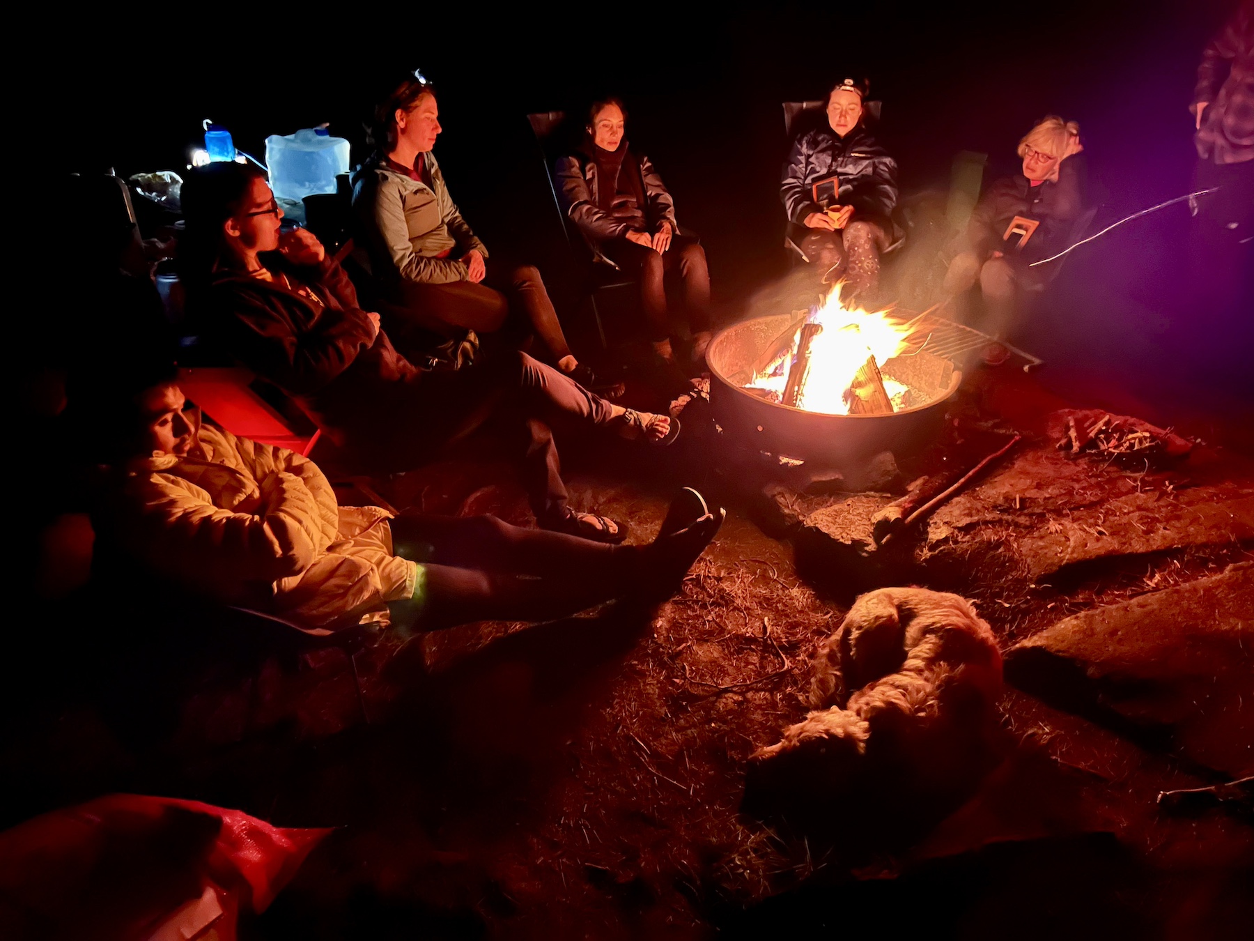a group of people sitting around a fire
