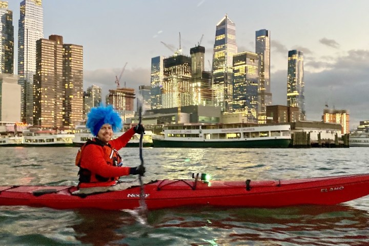 a small boat in a body of water with a city in the background
