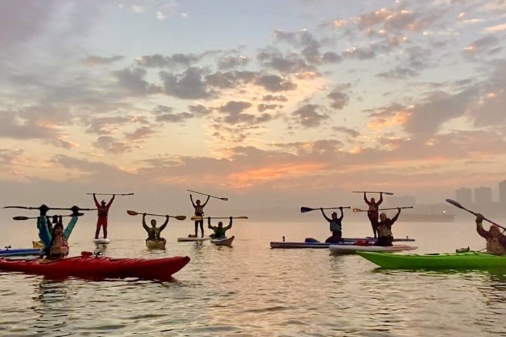 a group of people rowing a boat in a body of water