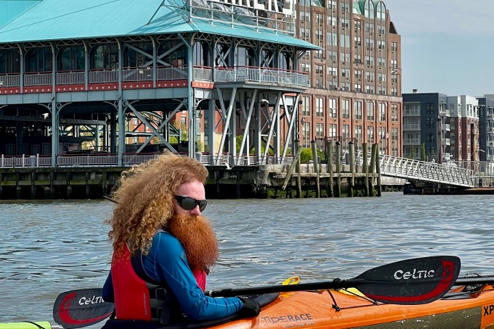 a man riding on the back of a boat in the water