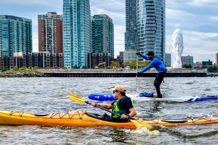 one person kayaking and one person paddle boarding at Jersey City
