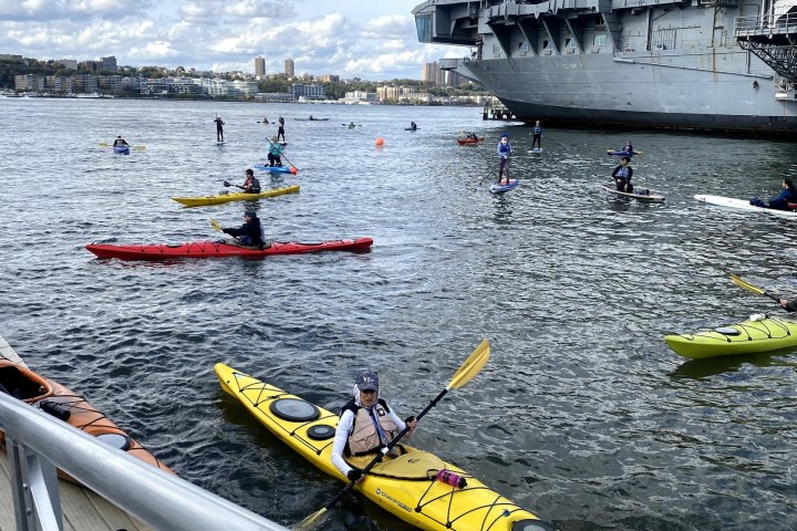 a group of people riding on the back of a boat in the water