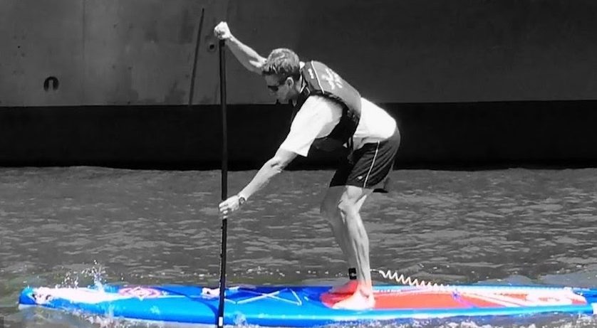 A man on a paddleboard practicing the hinge technique for a forward paddle stroke and being reviewed through video feedback during his 6-hour FastTrack paddleboard lesson.