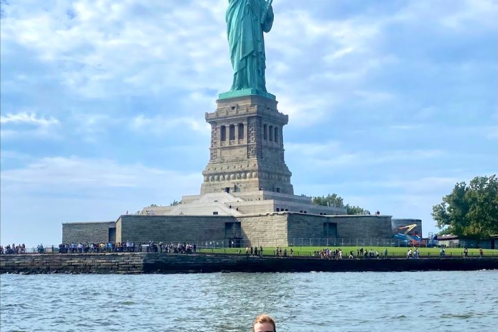 a woman in a kayak at the Statue of Liberty