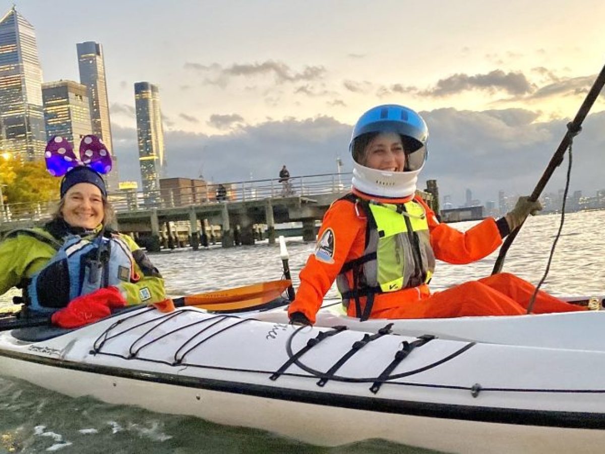 Kayakers during Halloween in costumes in front of Hudson Yards.