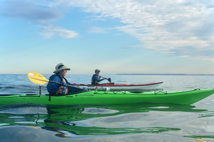a person in a green boat on a body of water