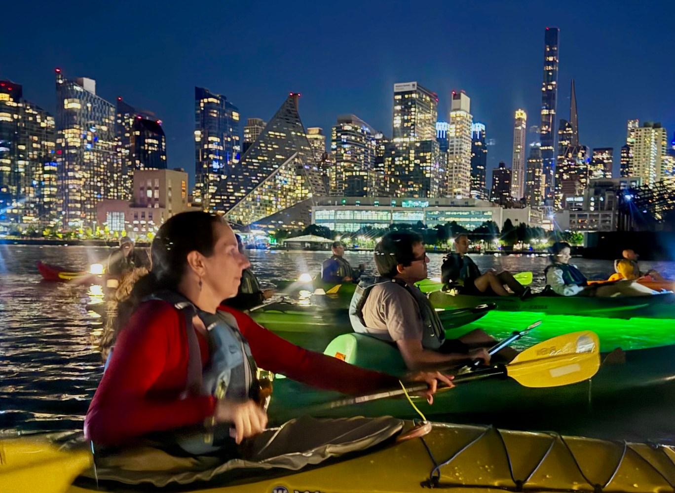 people kayaking in the dark at night in NYC