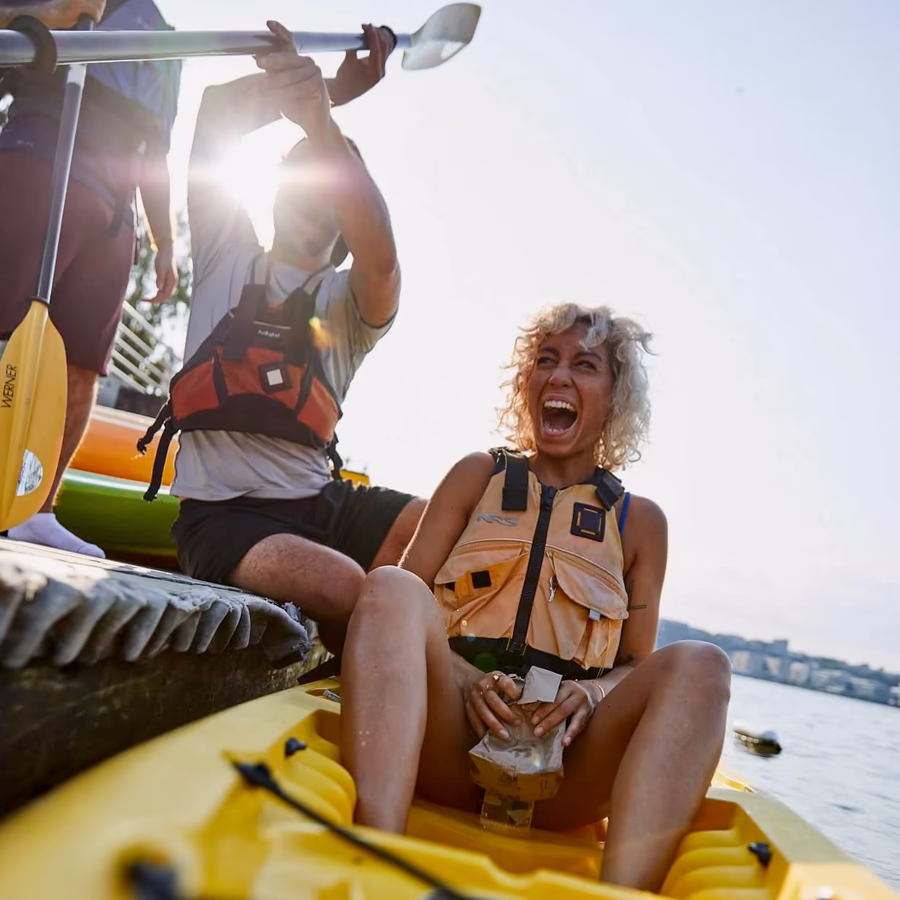 A beginner kayaker looking thrilled and excited while getting a professional launch from the Manhattan Kayak dock. Perfect for first-timers at Pier 84, showing how easy it is to start your Hudson River adventure.