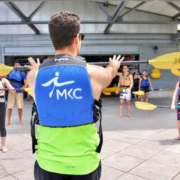 A Manhattan Kayak Co instructor standing on Pier 84 showing a group of people how to kayak, helping them to build basic kayak stroke technique before their first launch onto the Hudson.