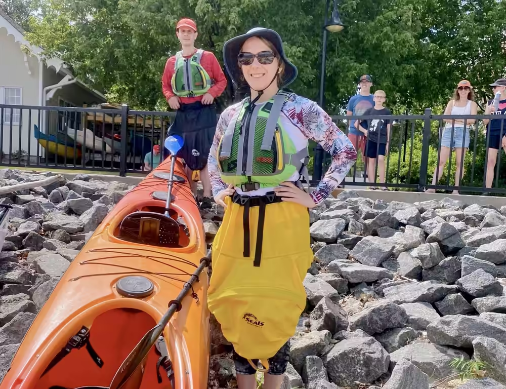 A couple standing alongside a tandem sea kayak near the Secret Beach.