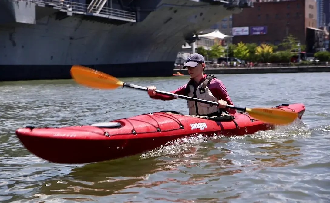 A focused student trading the treadmill for the Hudson River, generating power and a clean wake during a quiet weekend Kayak Basics class.
