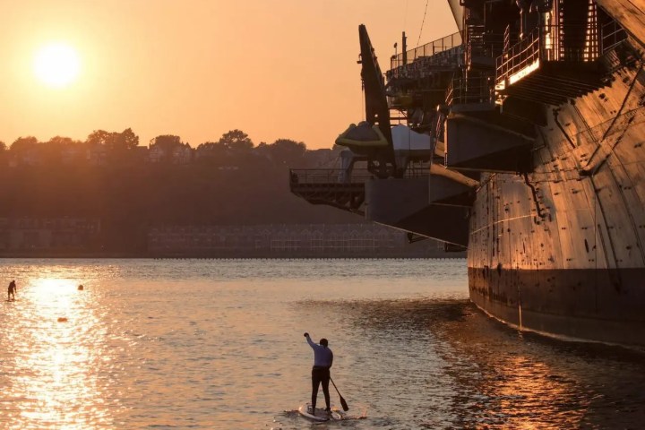 Paddler at sunset on the Hudson River, a cool alternative to crowded NYC beaches and pools during a heatwave.