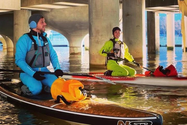 two paddle boarders under Little Island in NYC