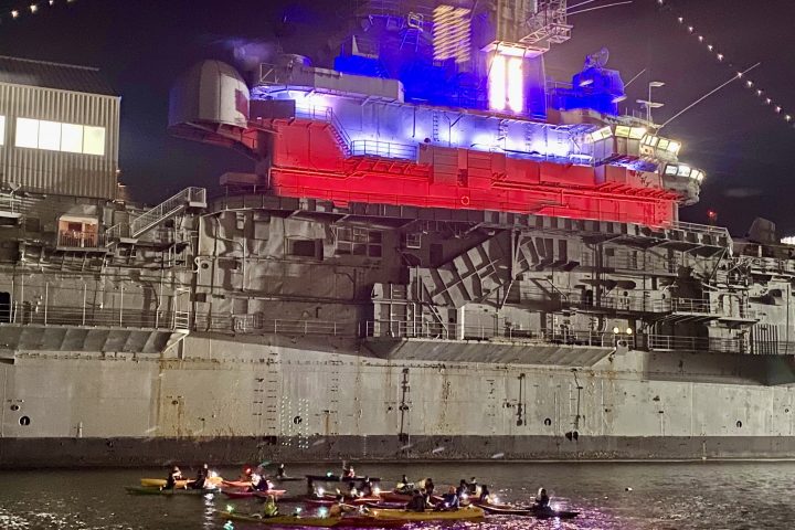 a group of kayaks at night by the Intrepid in Manhattan before a night kayaking trip
