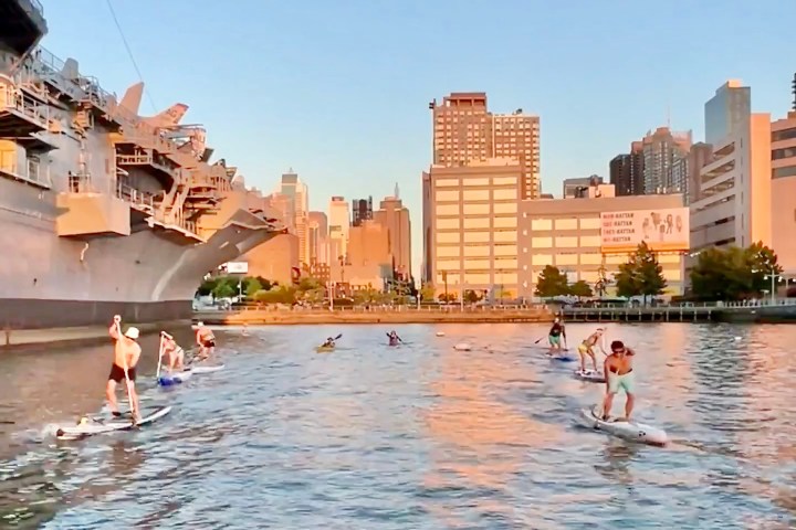 a group of people standing next to a body of water