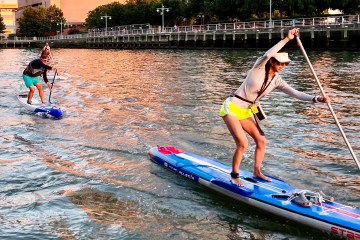 a woman riding a stand up paddle board in the water