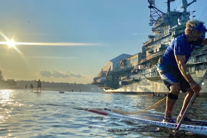 a man riding on the back of a boat in the water