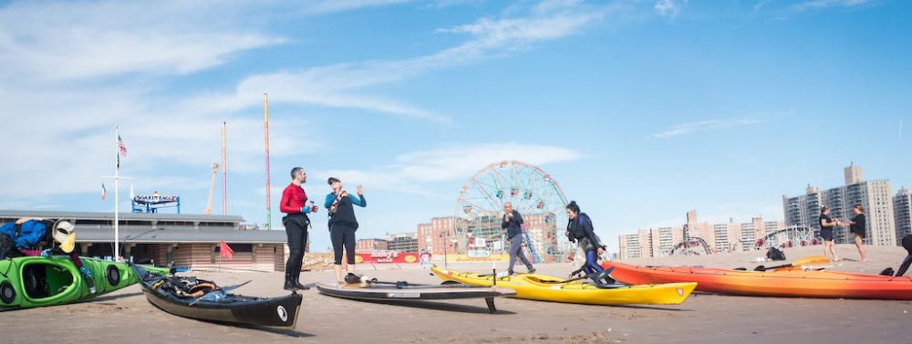 A group of kayakers on the beach at Coney Island Beach & Boardwalk.