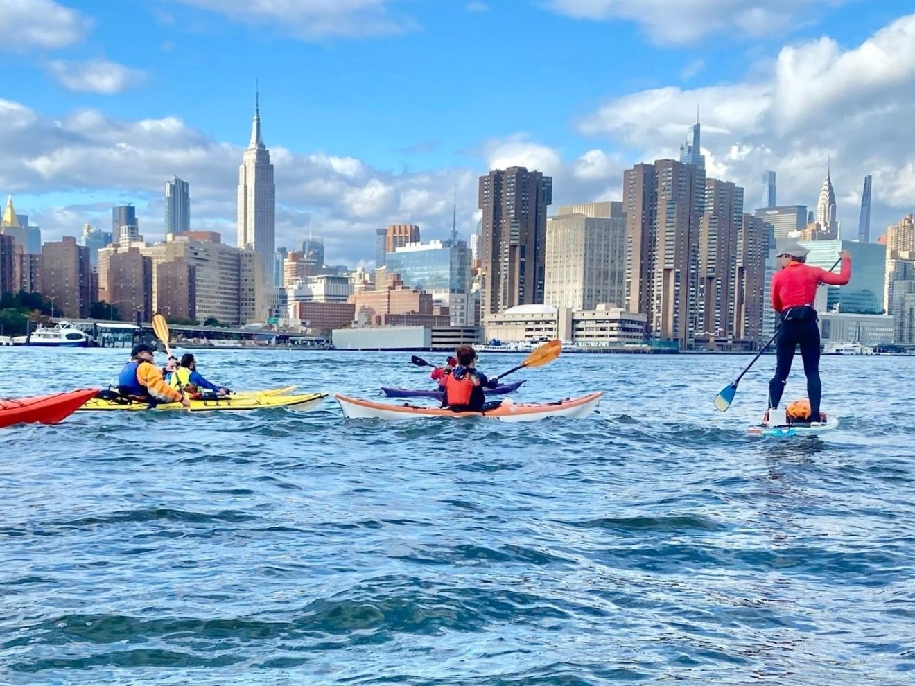 a group of people riding on the back of a boat in the water