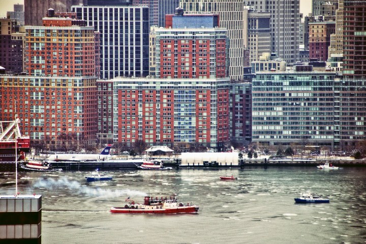 a small boat in a body of water with a city in the background