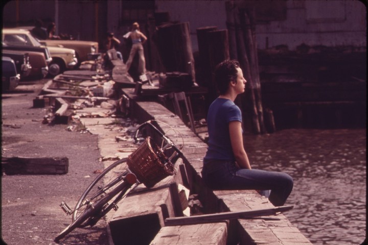a person sitting on a bench in front of a laptop