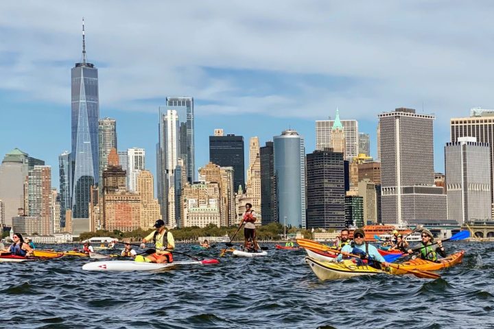 a small boat in a body of water with a city in the background