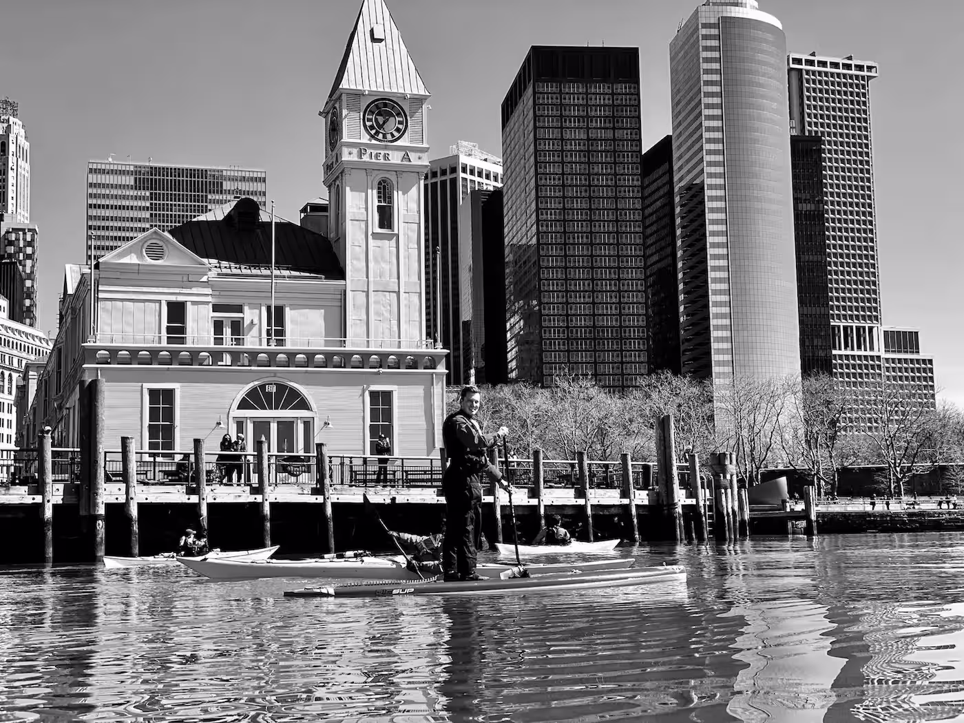 A man paddleboarding outside of City Pier A at The Battery of NYC.