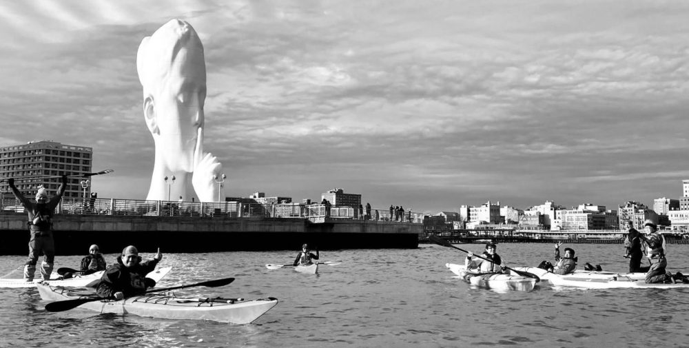 kayakers and SUPers at the Water's Soul sculpture in Jersey City
