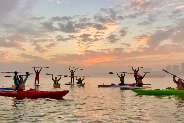 a group of people rowing a boat in a body of water