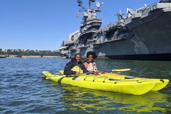 a man riding on the back of a boat in the water