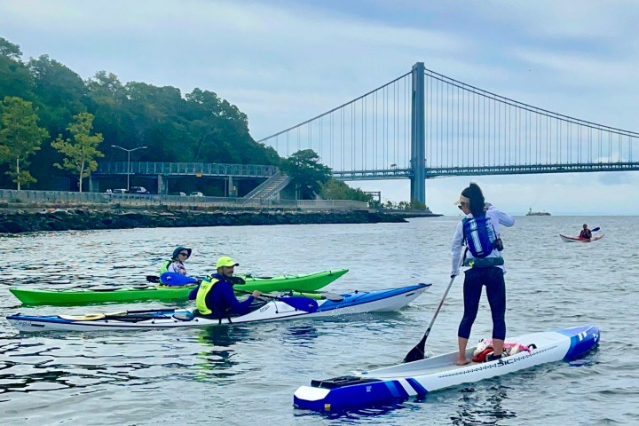 a group of people rowing a boat in a body of water