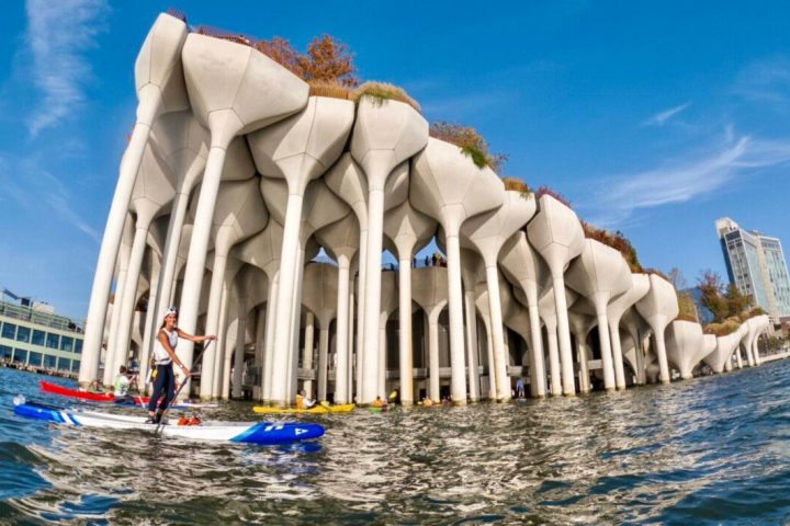 a woman riding a stand up paddle board at Little Island in NYC