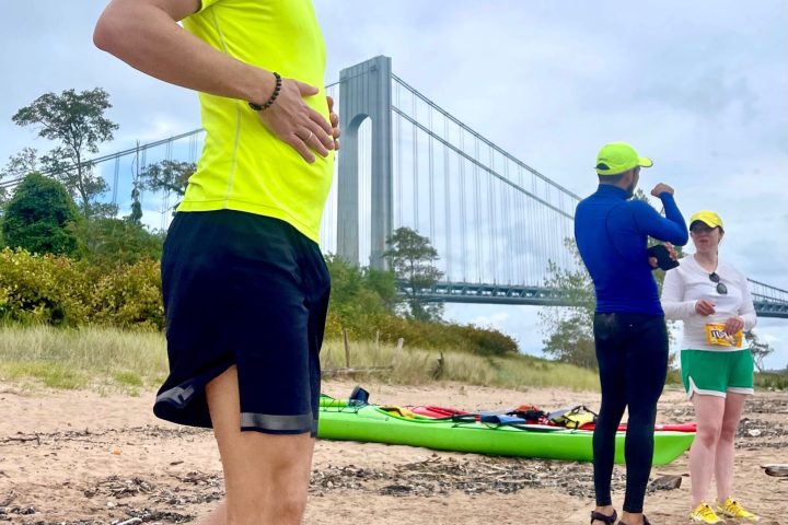 a man standing a beach near Verrazano-Narrows Bridge