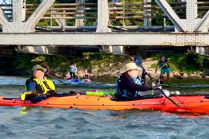 a group of people riding kayaks at Spuyten Duyvil Bridge