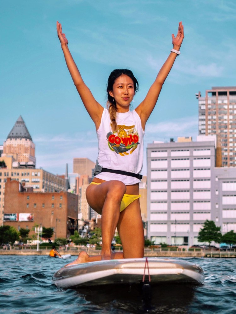 a woman standing next to a body of water