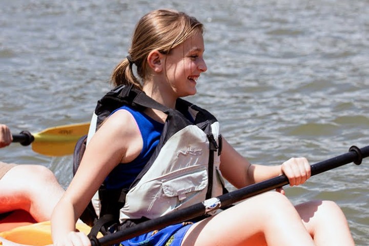 a woman rowing a boat in a body of water