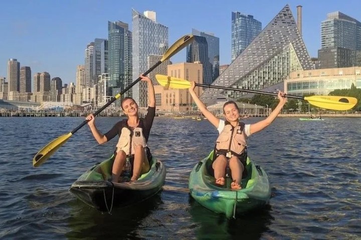 two women riding kayaks in NYC