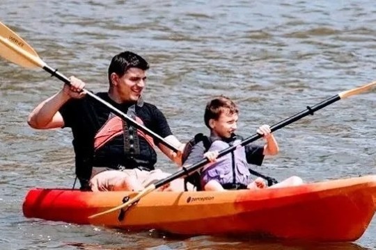 father and son riding a kayak together