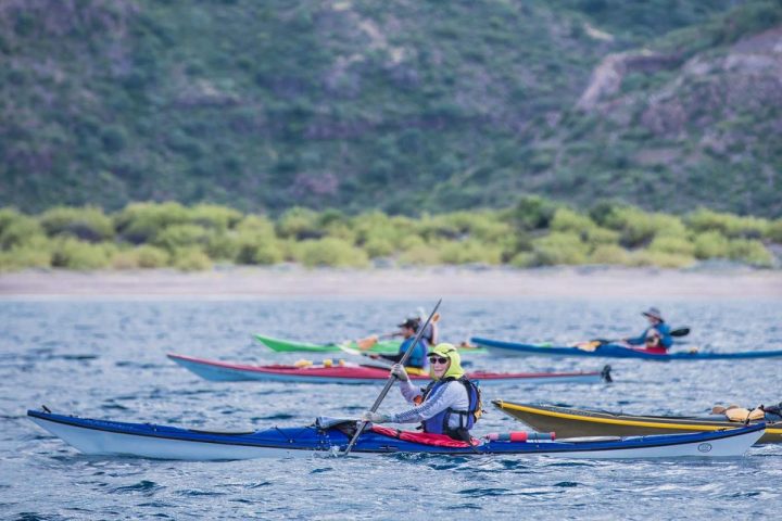 a group of people rowing a boat in the water