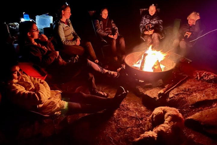a group of people sitting around a fire