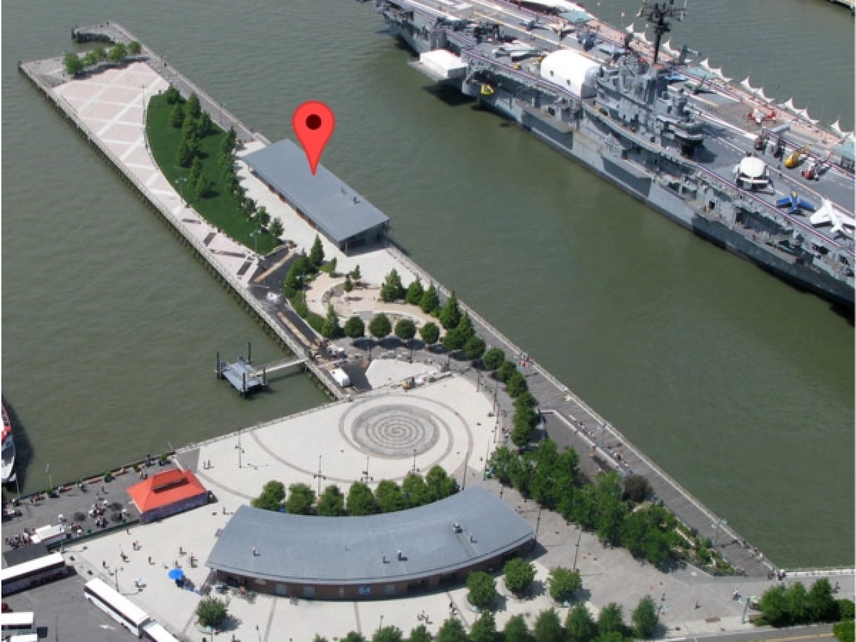 Aerial view of Manhattan Kayak Co. location with the USS Intrepid docked by Pier 84 with a circular plaza and buildings nearby.
