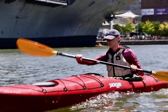 A focused student learning how to kayak during Manhattan Kayak Co's Sea Kayak Basics 1 Class on the Hudson River at Pier 84.