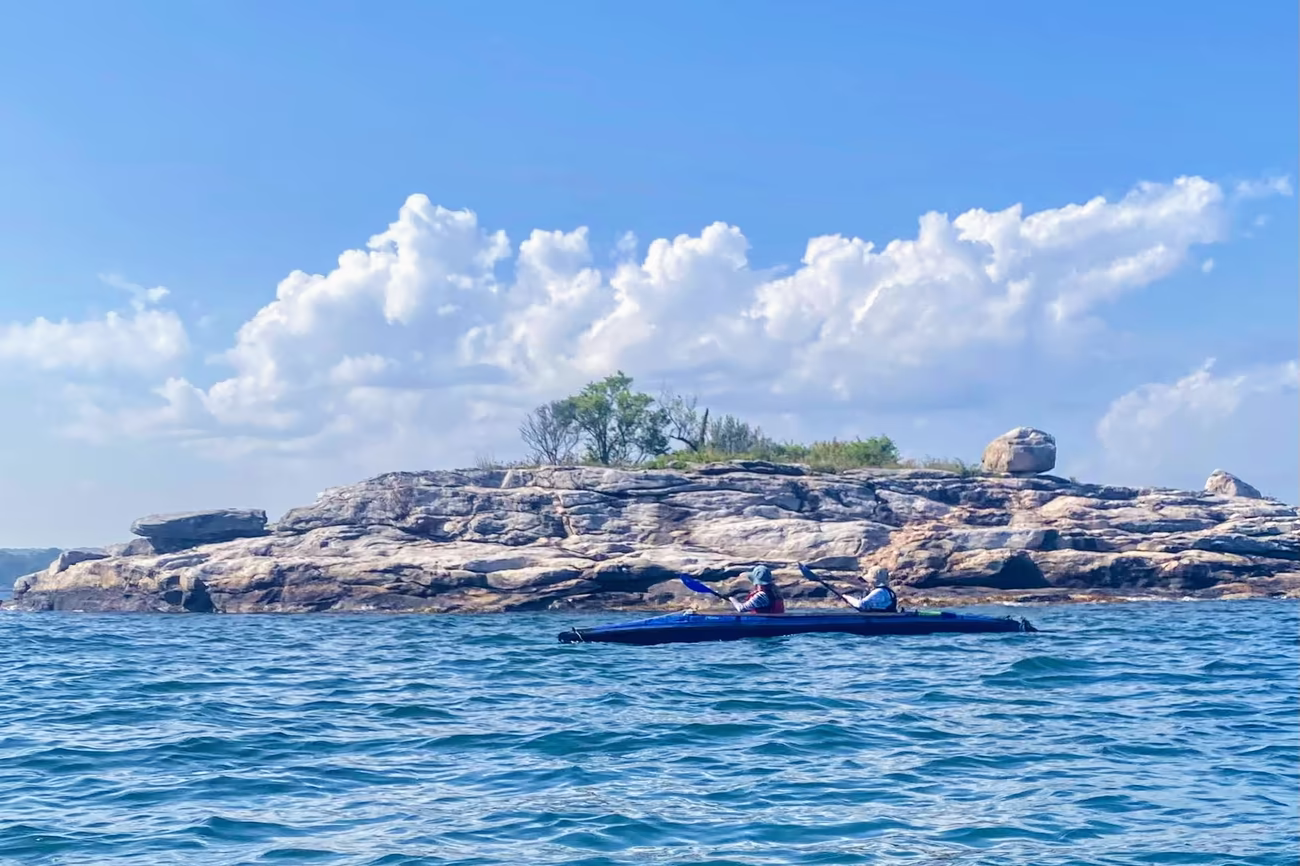 Kayakers exploring the rocky, pink granite islands of the Long Island Sound on an outdoor wilderness escape from New York City.