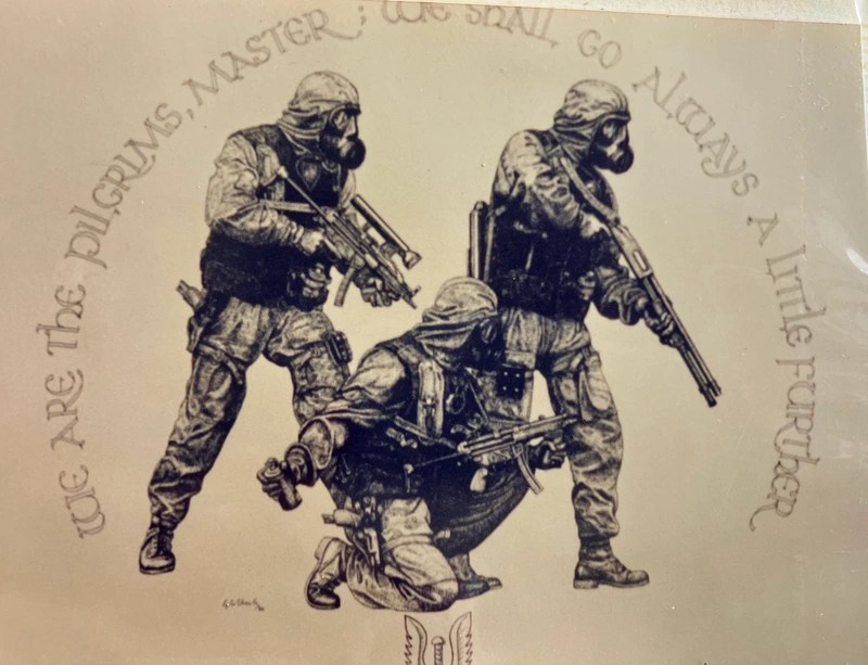 Three soldiers in tactical gear and gas masks aiming weapons.
