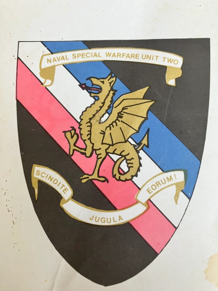 Emblem with dragon on striped shield, text 'Naval Special Warfare Unit Two'.